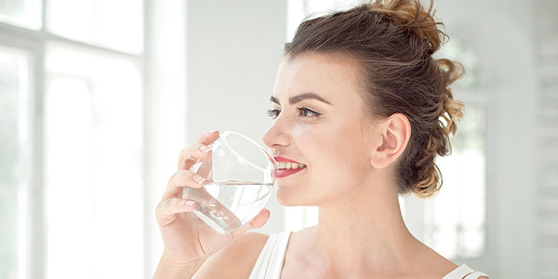 ragazza che beve acqua pulita dal bicchiere